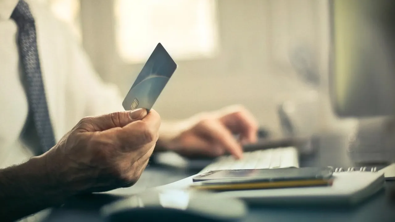 Person holding a credit card while on the phone with a bank